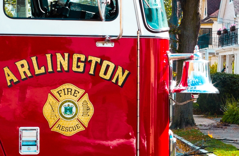 The shiny bell on an Arlington fire engine as it is parked across Freeman Street while responding to a downed power line (background). October 22, 2013. 