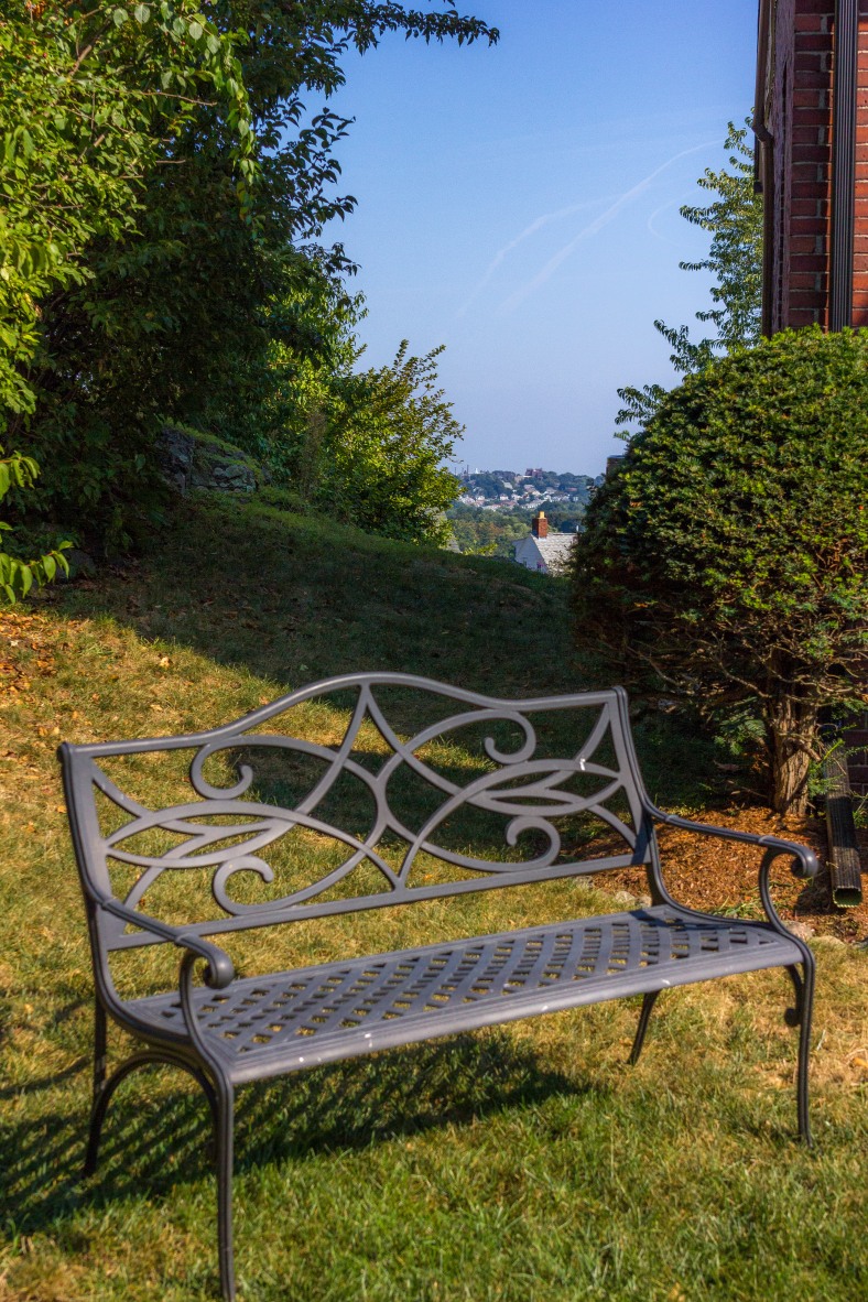 A bench in the front yard of a Richfield Road home offers views of the street, while out back there are views of Boston and its surrounds. September 11, 2013.