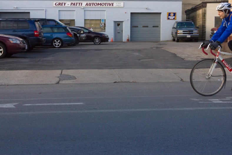A biker passes an auto body shop on Massachusetts Avenue. March 21, 2014.